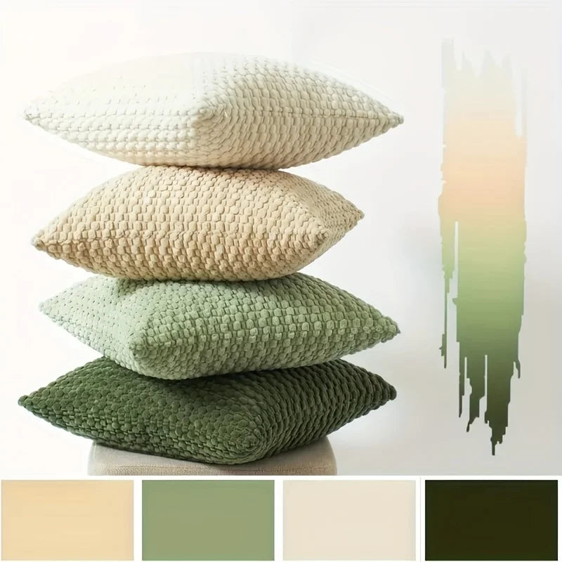 A stack of four decorative pillow covers in varying shades of olive green and beige on a white background.