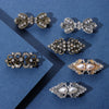 A collection of vintage swirl clip brooches featuring silver and gold-toned metalwork and clear stones on a blue background.