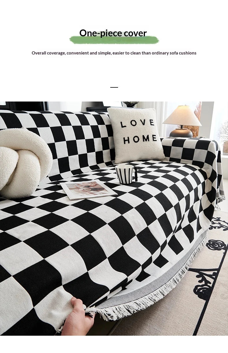 A black and white checkerboard sofa slipcover featuring a decorative throw pillow.