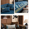 A blue sofa mat cover featuring a Christmas deer pattern with green and gold accents.