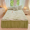 A bed dressed with a green and white striped linen set featuring a plush duvet and pillows.