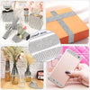 A collection of crystal rhinestone ribbon and craft tools, including a ribbon on an orange gift box and a pink smartphone cas