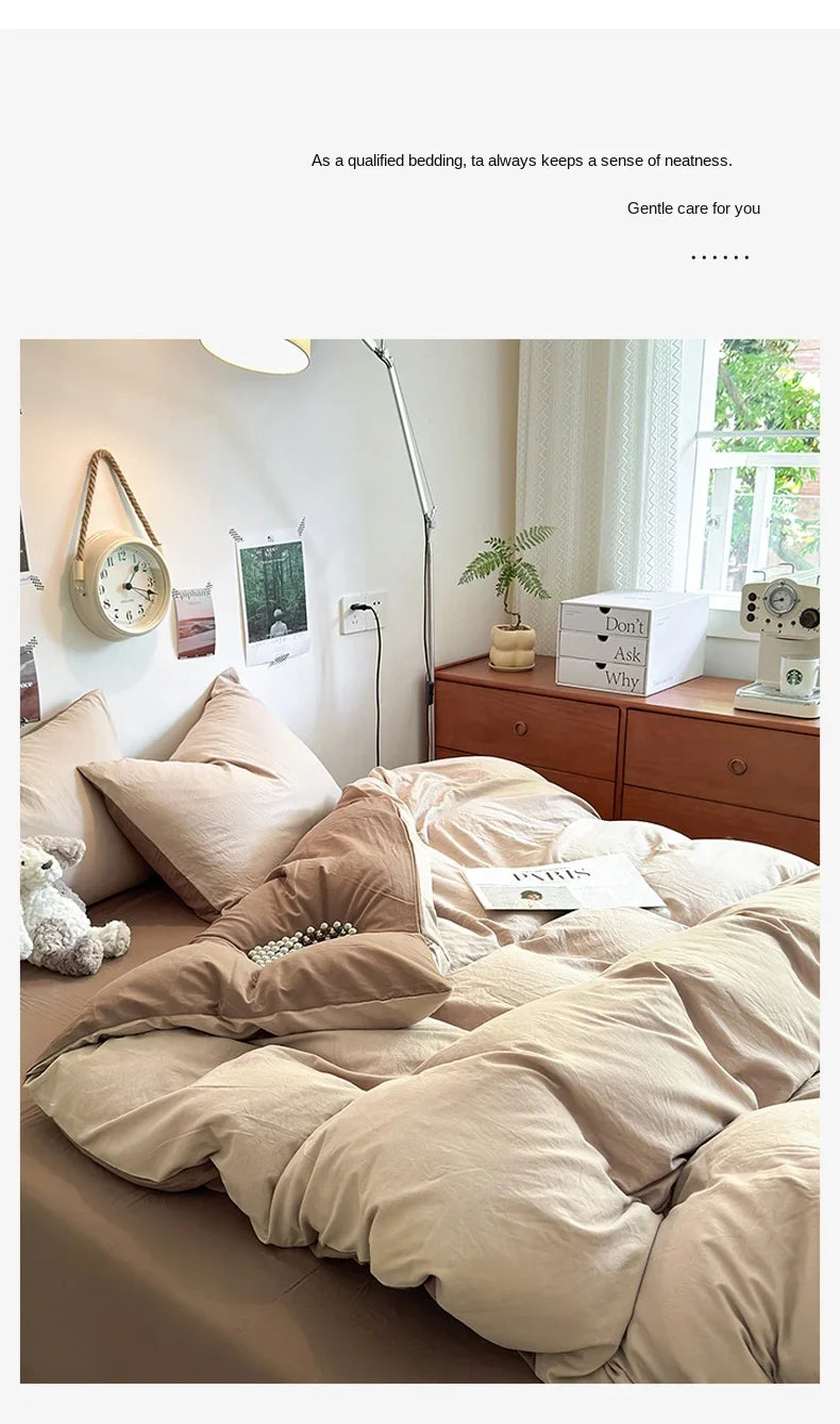 A bed dressed with beige and cream bedding, pillows, and a quilt set in a bright bedroom.