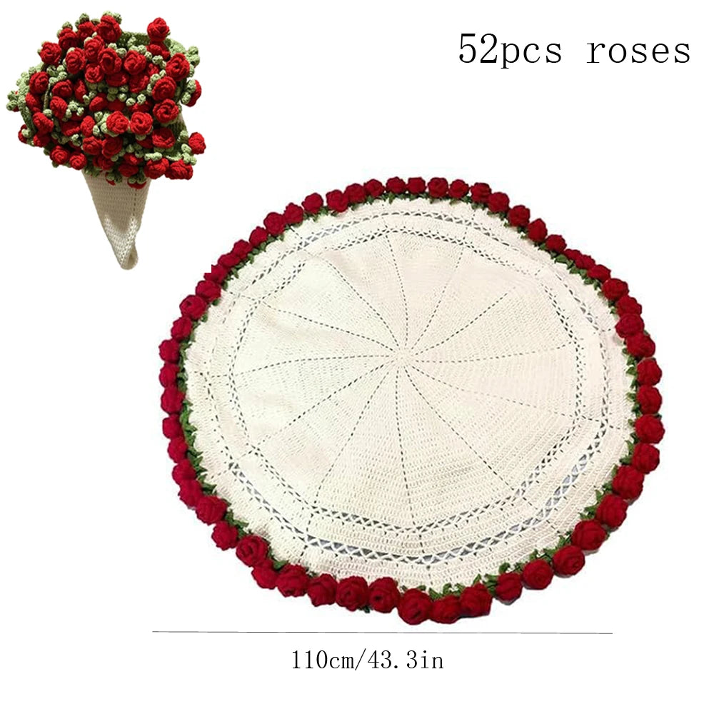 A round cream knitted throw blanket decorated with a red floral border and a separate bouquet of red roses.