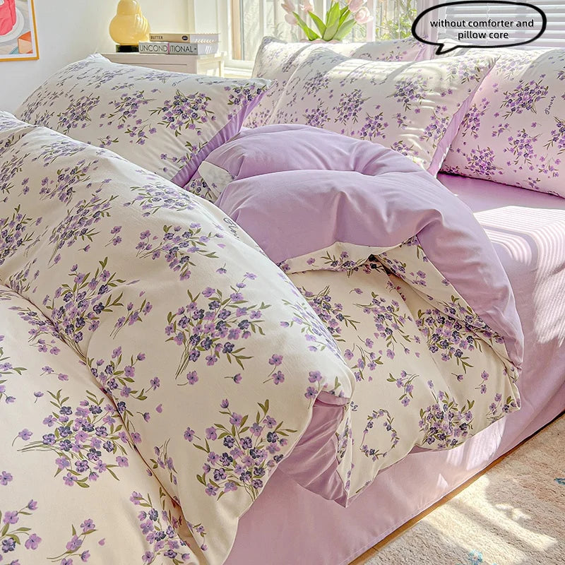 A set of lavender print duvet covers and pillowcases featuring a floral pattern on a bed.