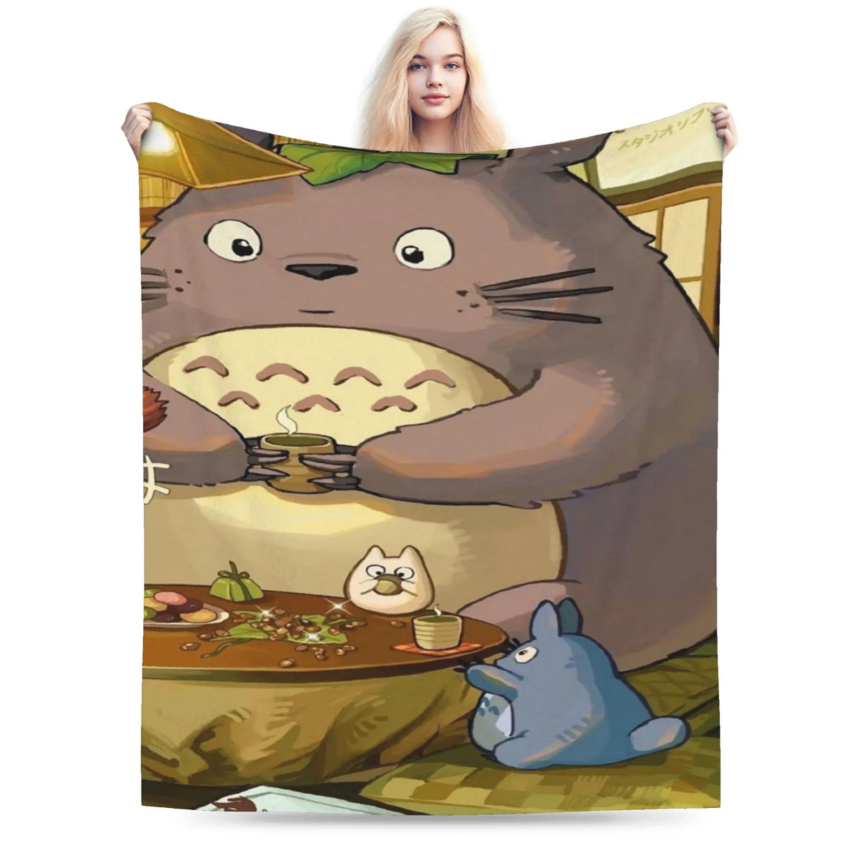 A fleece throw blanket featuring a Totoro character illustration of a large brown cat with green accents.