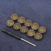 A set of ten antique gold-toned metal snap buttons with floral designs arranged on a dark blue fabric.