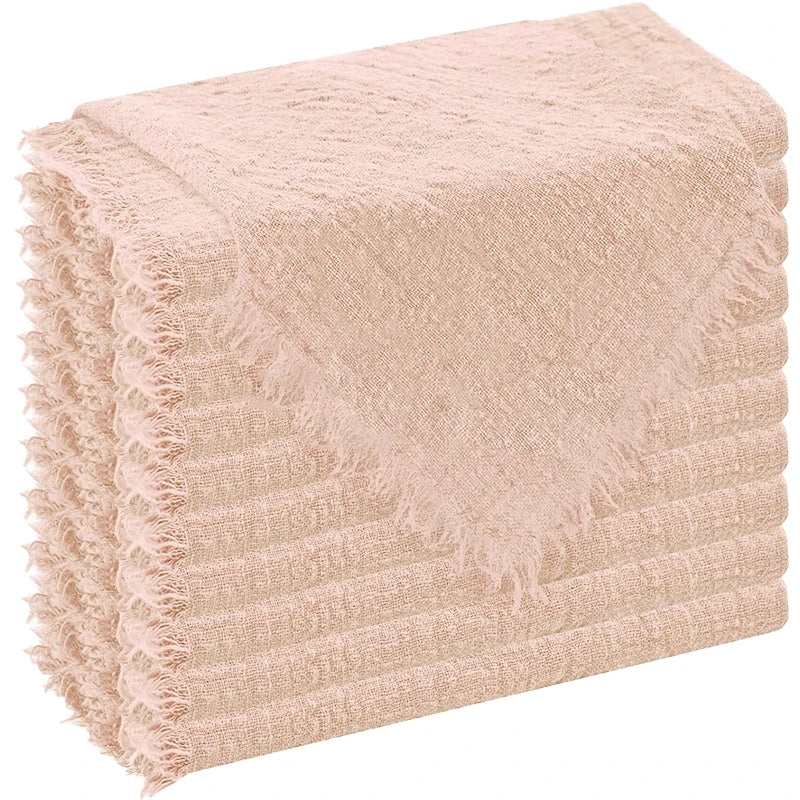 A stack of light pink, textured cloth napkins with frayed edges.