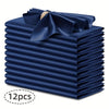 A stack of twelve navy blue silky satin dinner napkins with a decorative bow.