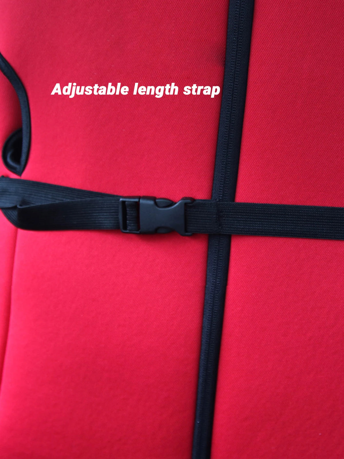 A close-up of a red baby car seat featuring an adjustable length strap and black webbing.