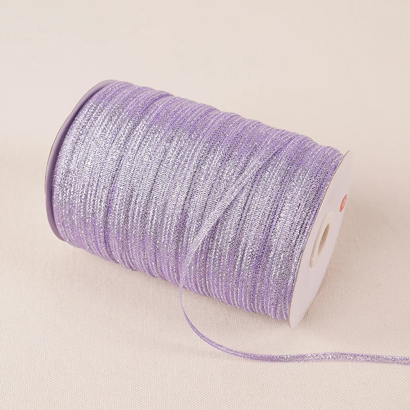 A roll of 10-meter gold and silver glitter satin ribbon is shown on a light background.
