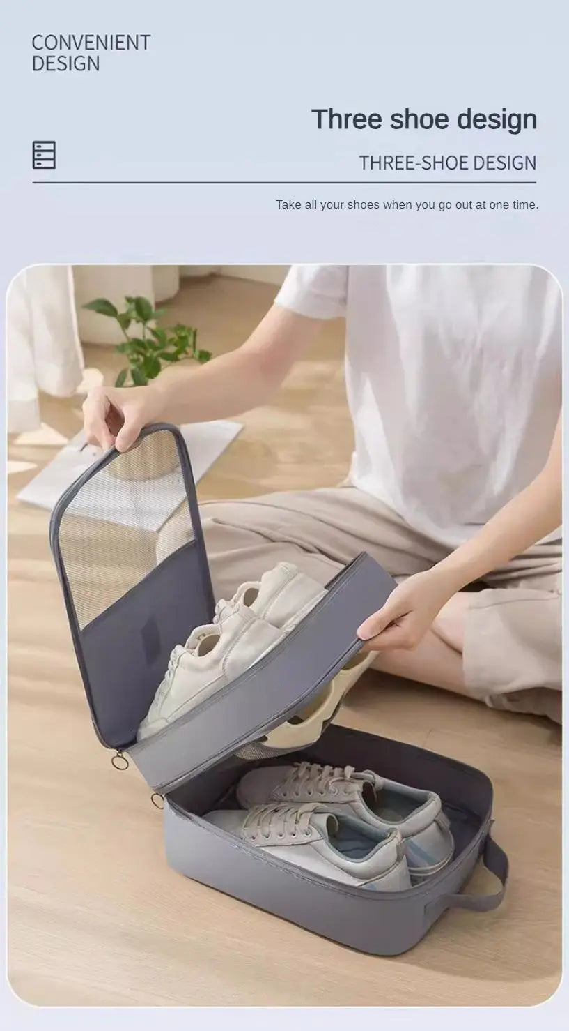 A person is using a portable shoe organizer bag to hold three pairs of shoes for travel.
