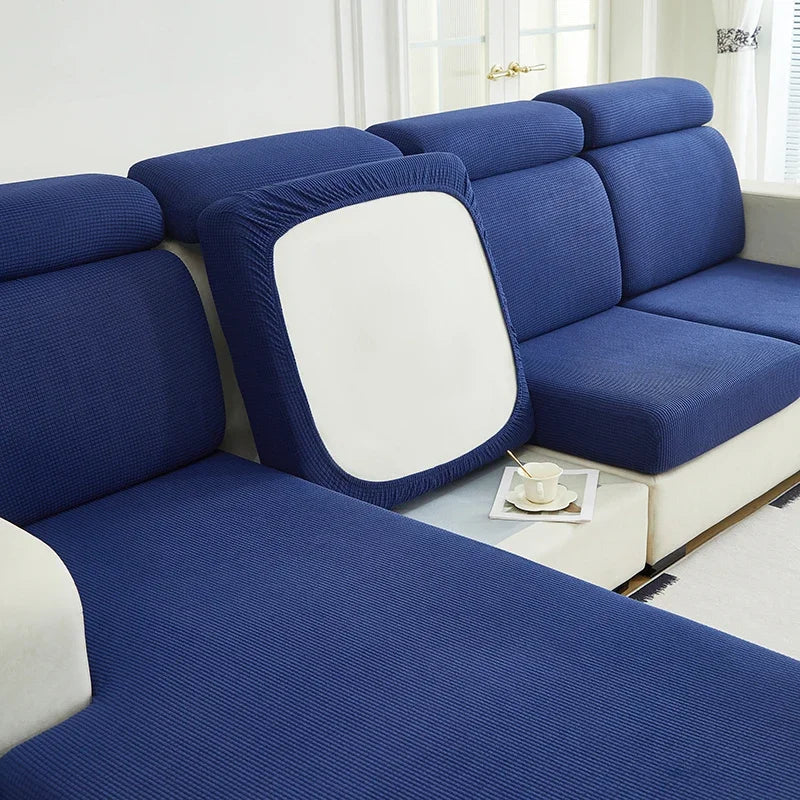 A deep blue Jacquard elastic sofa cushion slipcover with a white backrest shown in a living room setting.
