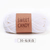 A skein of white yarn labeled Sweet Candy Yarns with a brown tag and Japanese text.