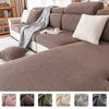 A close-up of a plush, ribbed brown sofa cushion cover with a gray patterned throw draped over it.