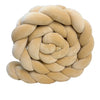 A round, light beige handmade knotted floor mat for bed decor.