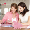 A woman is signing a personalized mom plaque keepsake for another woman in a bright indoor setting.