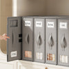 A row of gray non-woven fabric storage boxes labeled with Japanese text is displayed on a white cabinet surface.