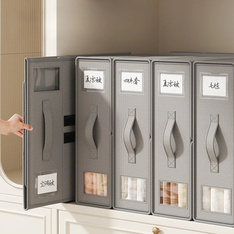A row of gray non-woven fabric storage boxes labeled with Japanese text is displayed on a white cabinet surface.