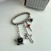 Silver adjustable watch keychain featuring a star-shaped watch face and a cross charm.
