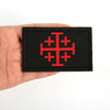 Black embroidered patch featuring a red military cross design on a hand.