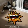 A bright orange and black starfish motif floor mat displayed on a wooden floor next to decorative skulls and pumpkins.