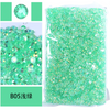 Bag of green resin rhinestones and a loose pile of similar green sparkling stones.