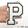 A black letter P patch with a white background is held in a hand.