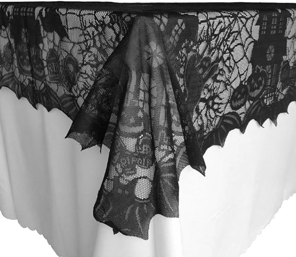 Black spider web lace table runner displayed on a white tablecloth.