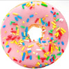 Pink donut-shaped plush throw blanket decorated with colorful sprinkles