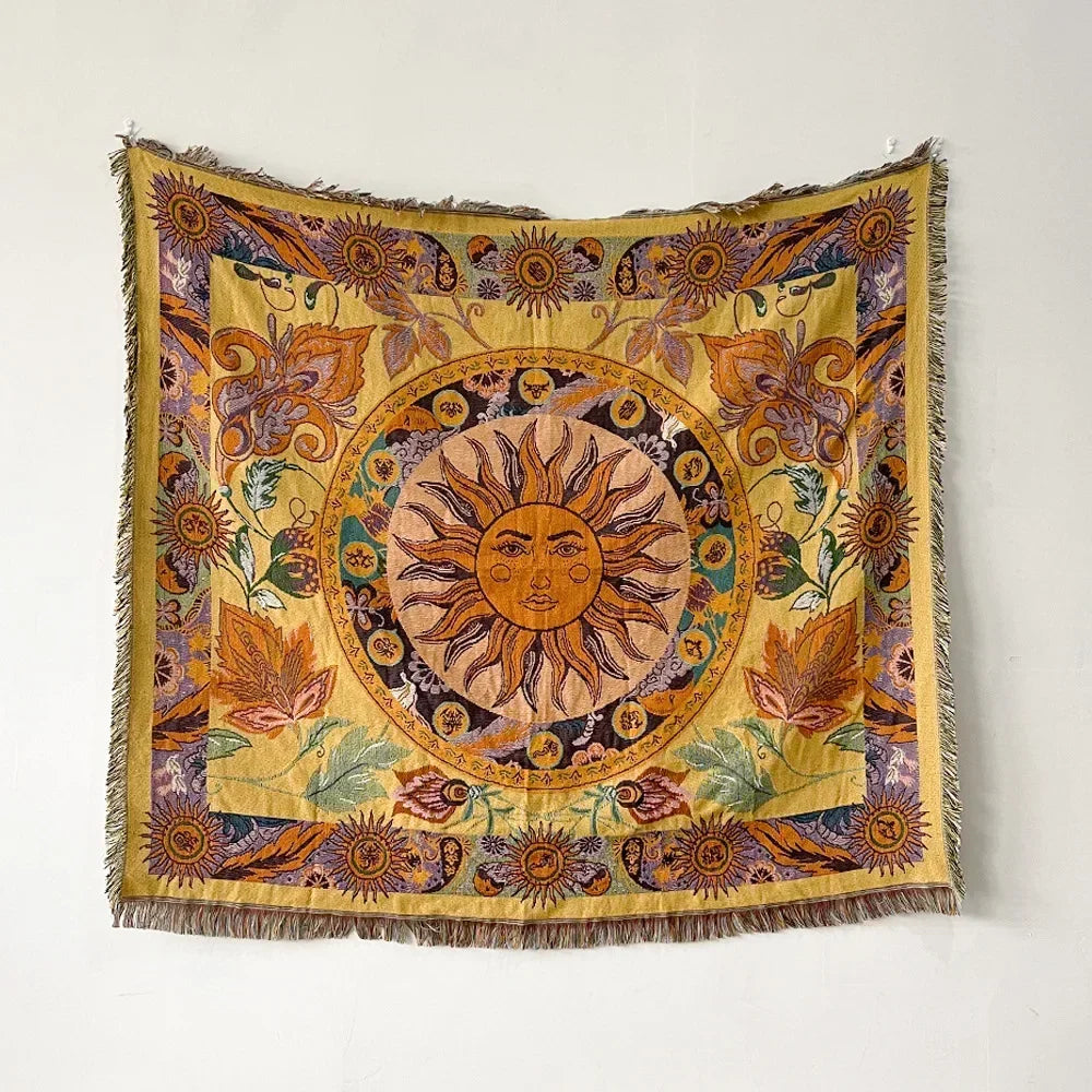 A richly colored bohemian geometric throw blanket featuring sun motifs and floral patterns on a yellow background.