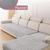 A light gray flannel sofa cover is displayed on a beige L-shaped corner sofa, showing the textured fabric detail.