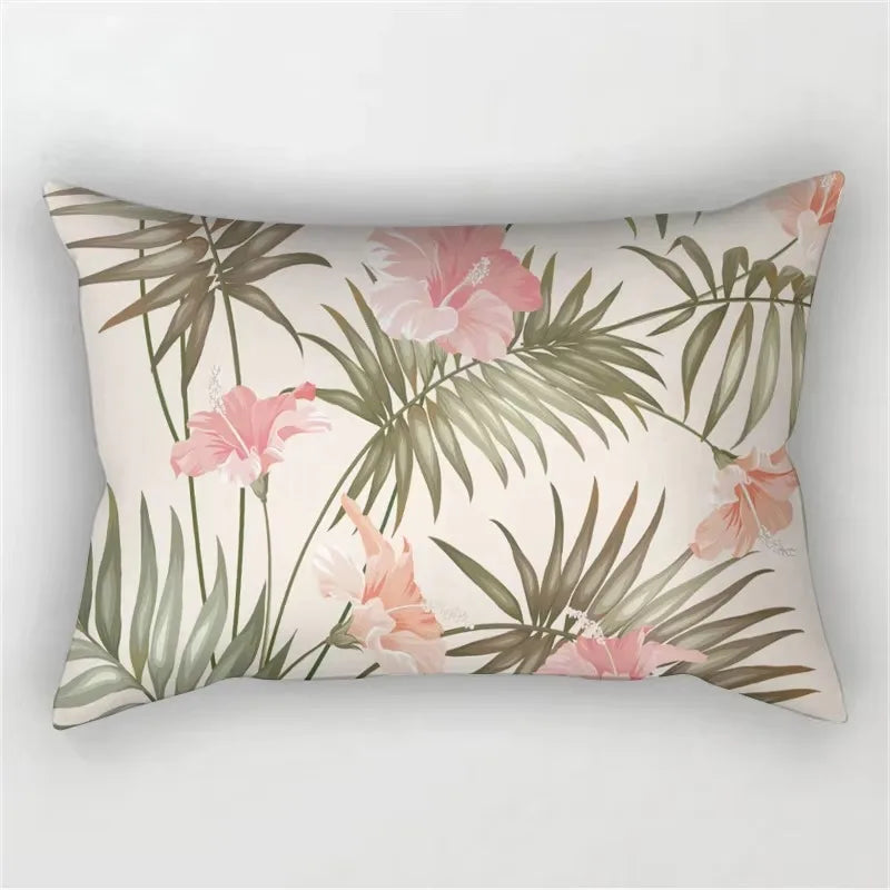A decorative pillowcase featuring a tropical leaf print with pink and green foliage.