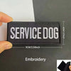 Black embroidered patch with white text SERVICE DOG on a dark background