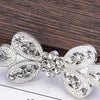 Silver rhinestone clothing clips shaped like leaves used to secure scarves