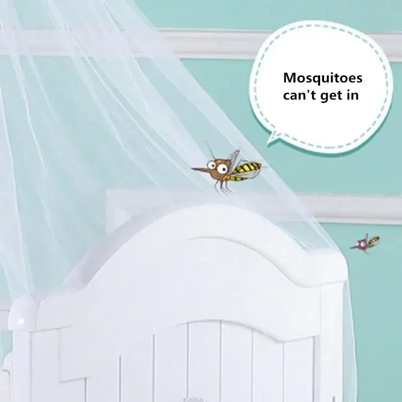 A mosquito is shown flying near a white crib with a sheer netting draped over it.