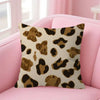 A decorative pillow cover with a leopard print pattern in shades of brown and gold resting on a pink sofa.