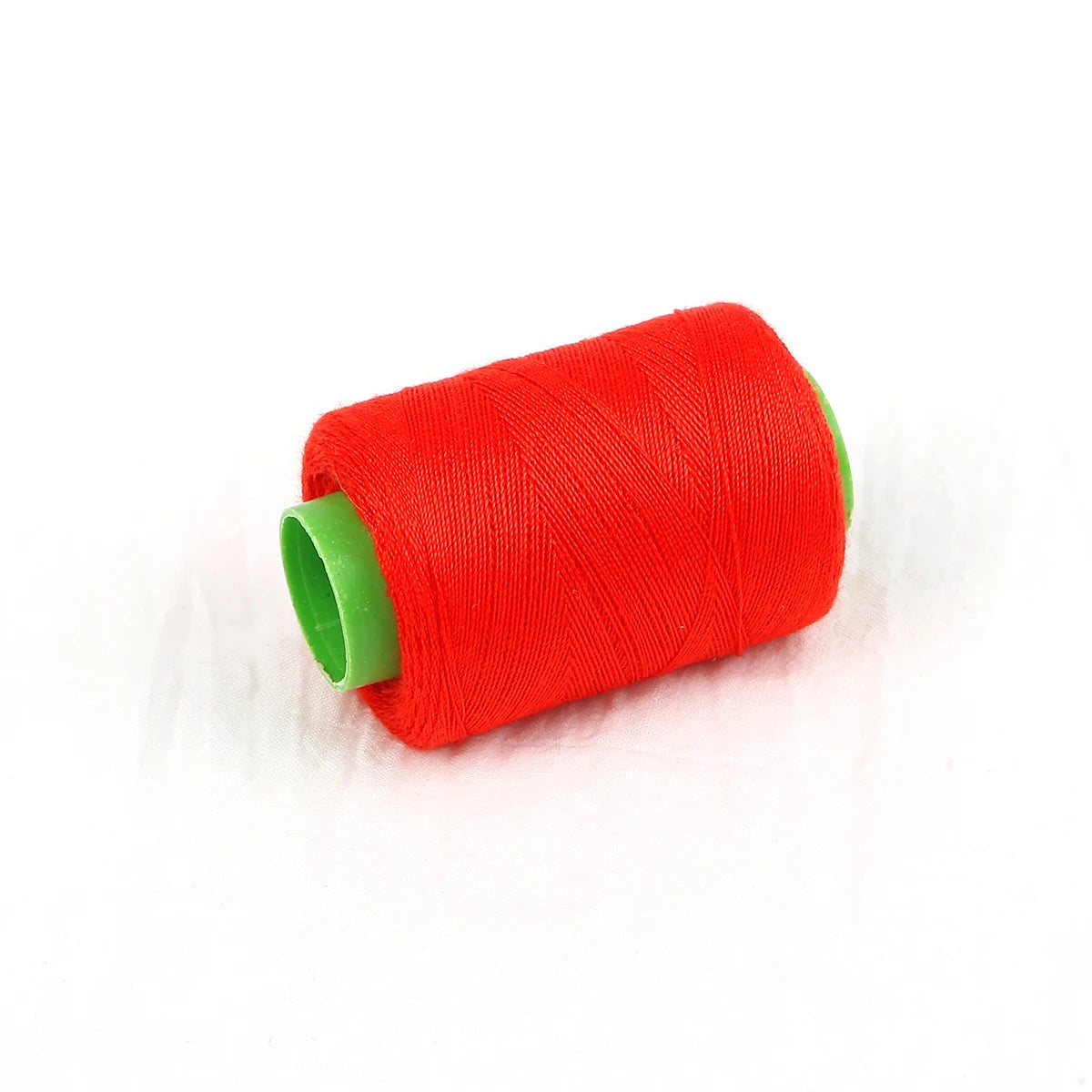 A roll of bright red sewing thread with a green core.