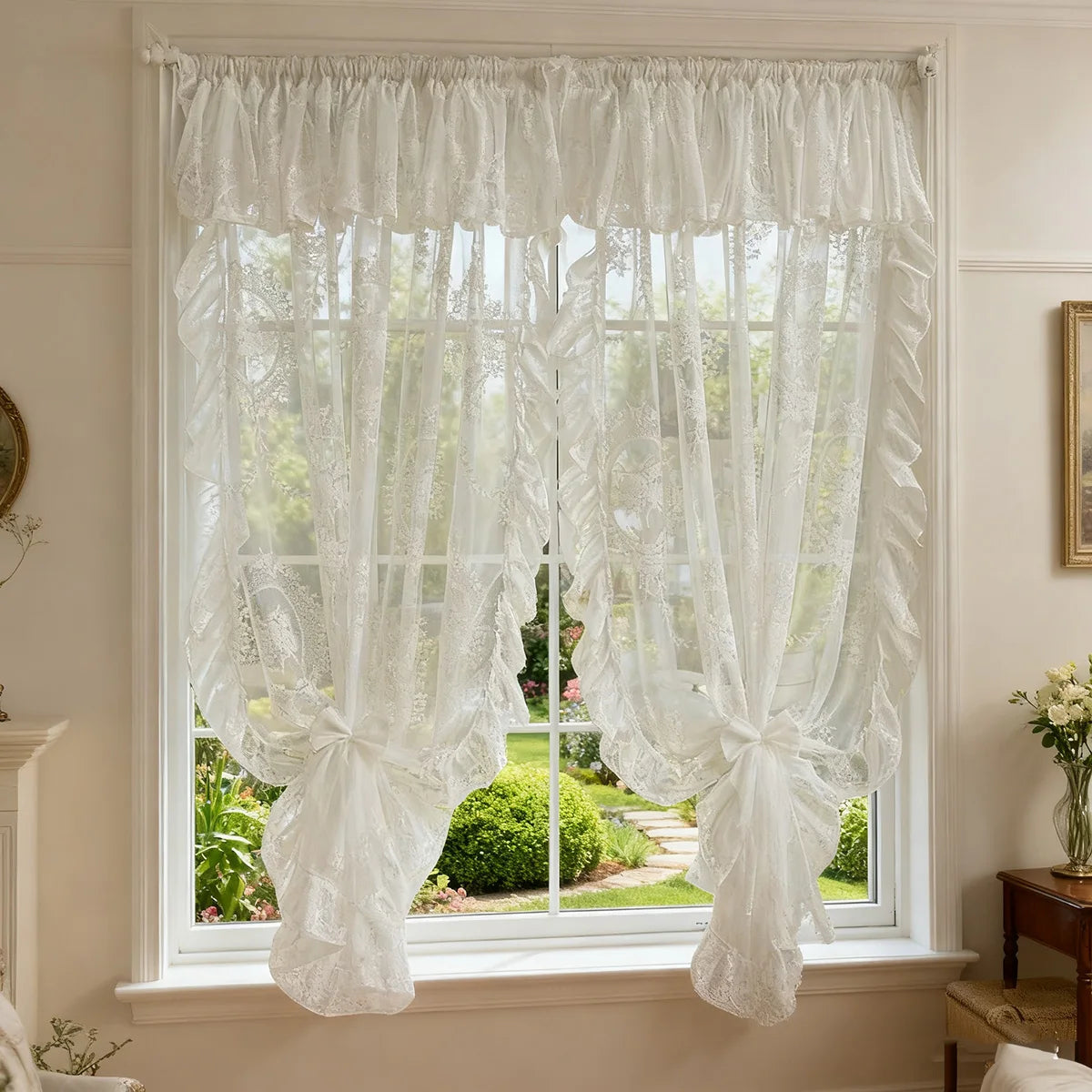 A sheer white curtain with ruffled lace trim and vintage floral design hanging in a window.