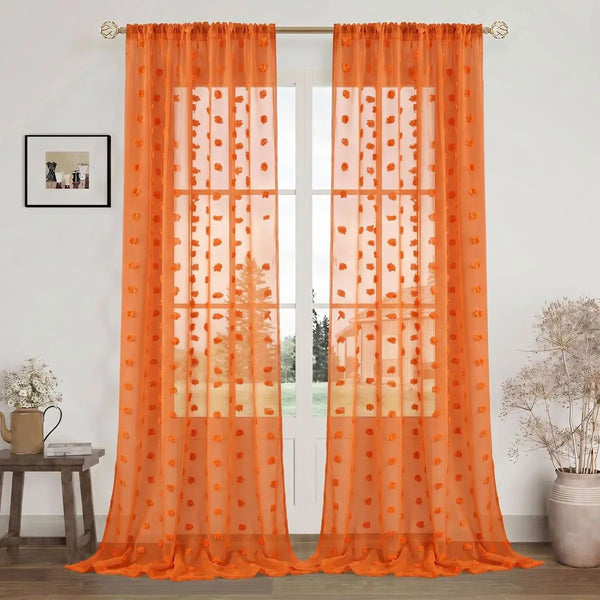 Orange pompom jacquard sheer curtain hanging in a glass door frame.