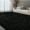 A dark gray plush long-pile area rug placed in a modern living room with sheer white curtains and a light sofa.