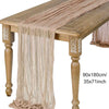 A beige semi-sheer gauze table runner draped over a wooden table.