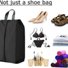 A black foldable organizer bag containing shoes, accessories, and clothing items.