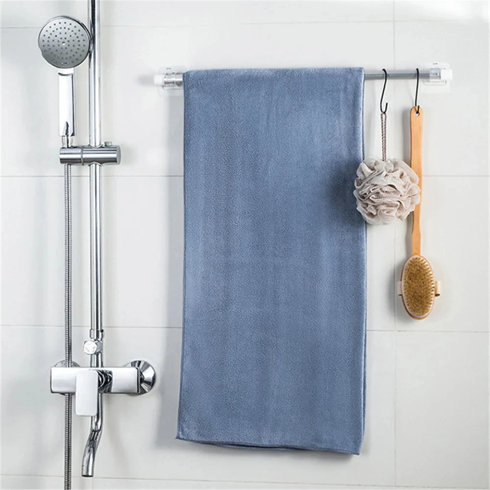 A blue towel hanging on a metal rack next to a shower fixture.