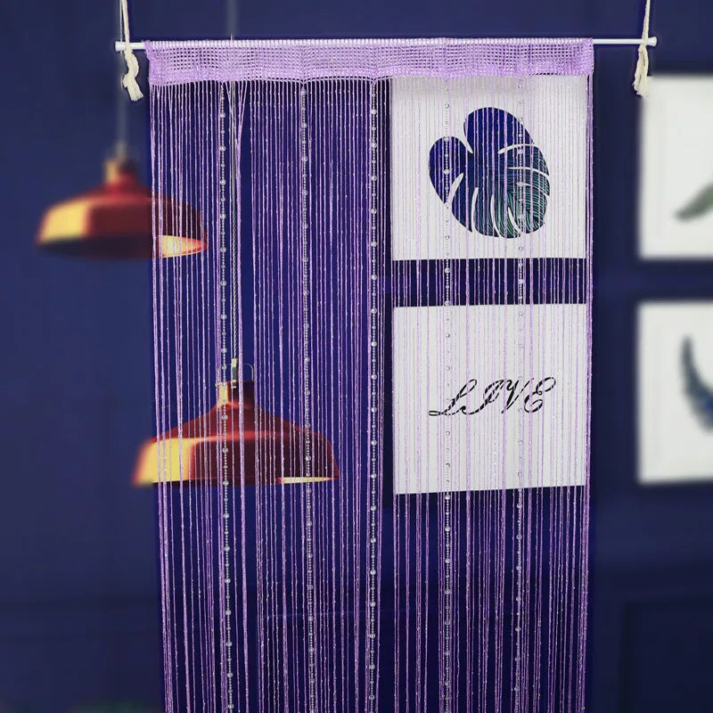 A purple beaded string curtain hangs, featuring a white heart design and the word LIVE.
