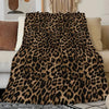 A luxurious leopard print flannel blanket draped over a light-colored sofa.