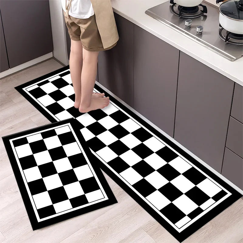 Two black and white diamond print non-slip kitchen rugs displayed on a light wood floor next to dark cabinets.