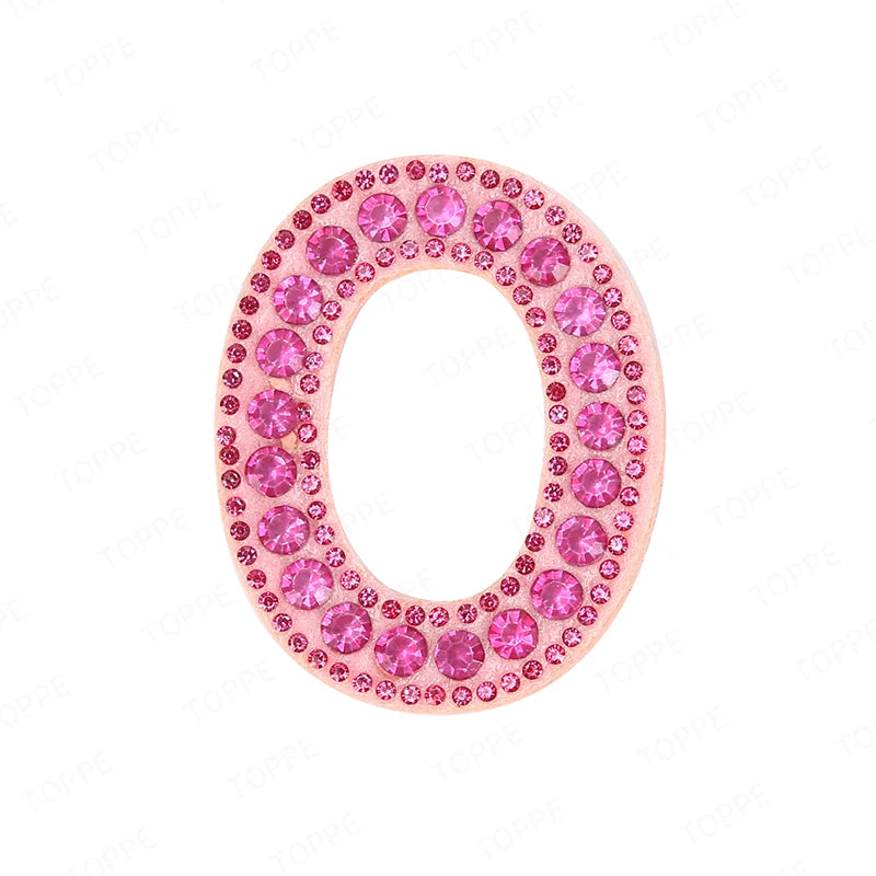 A pink letter O patch covered in small pink rhinestones.