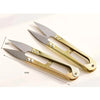 A pair of gold-toned U-shape sewing scissors with silver blades shown on a white background.