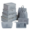 A set of gray fabric travel storage organizers including stacked boxes and a zippered pouch.
